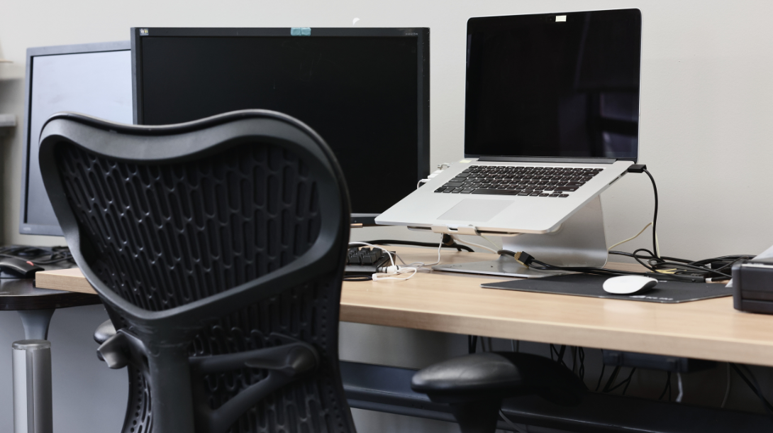 An empty computer station with multiple monitors.
