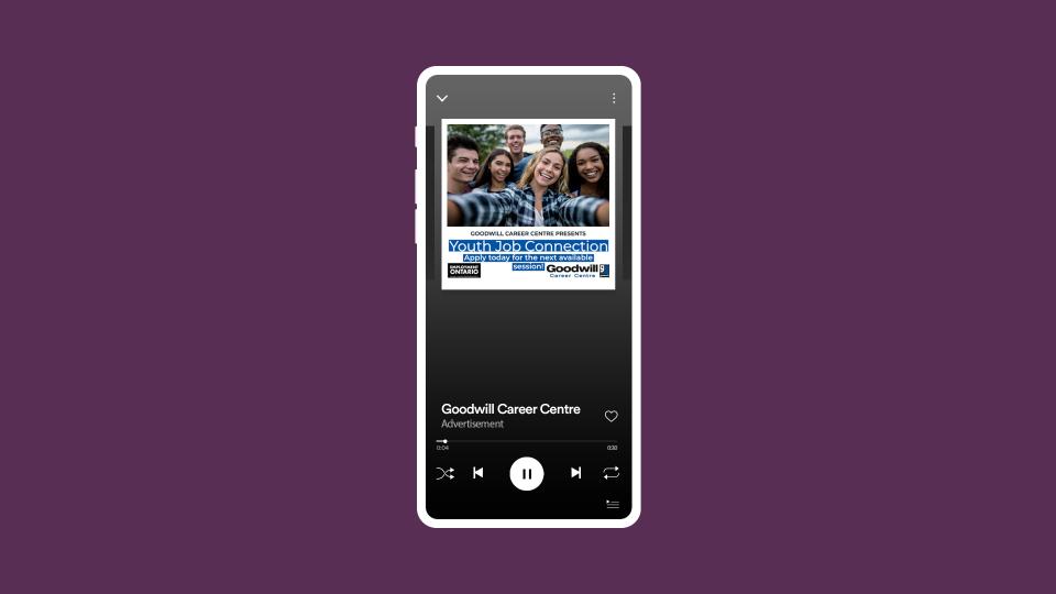 Purple background with a white phone showing the Goodwill Spotify ad.