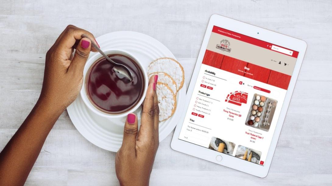 A woman browses the Fancy Farmerettes store on her tablet while having tea.