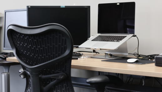 An empty computer station with multiple monitors.